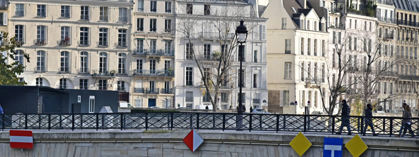 French people crossing a bridge over the Seine river in Paris France