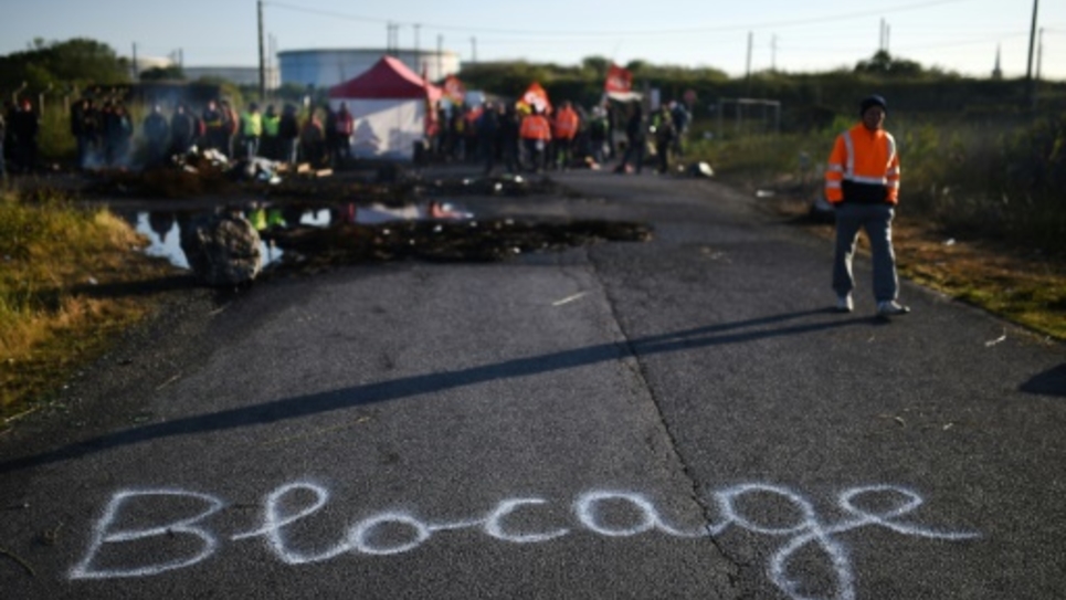 Un salariÃ© bloque l'accÃ¨s au dÃ©pÃ´t de carburant de la raffinerie Total Ã  Donges, prÃ¨s de Nantes, le 23 mai 2016