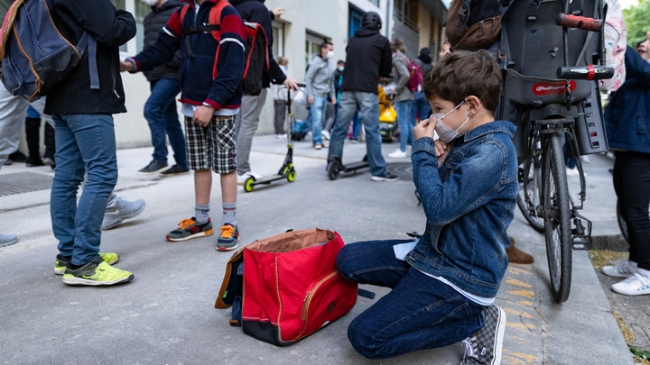 Un enfant ajuste son masque avant d'entrer à l'école, le 26 avril 2021 à Paris
