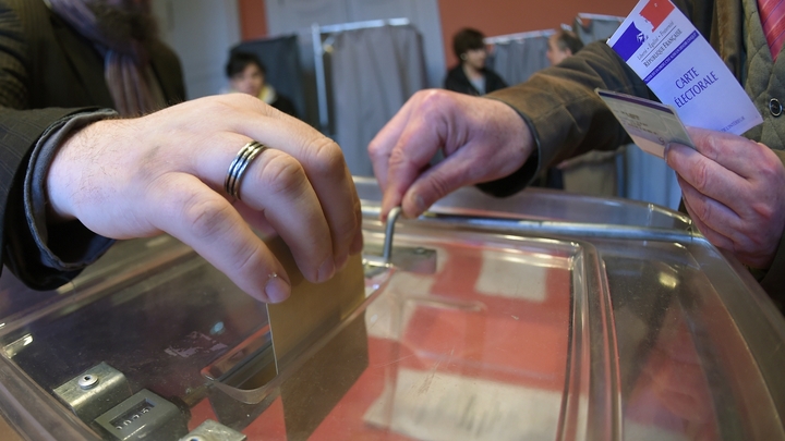 Un homme glisse son bulletin de vote dans l'urne, le 7 mai 2017 à Strasbourg, lors du deuxième tour de la présidentielle opposant Emmanuel Macron à Marine Le Pen