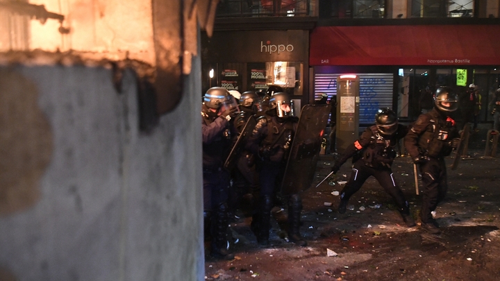 Des policiers se mettent à couvert lors de heurts avec des manifestants, le 28 novembre 2020 à Paris