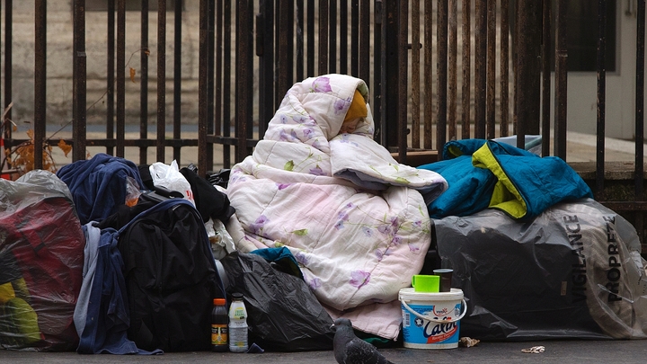 Une femme sans-abris est enveloppée dans une couverture sur le trottoir d'une rue parisienne, le 3 décembre 2014