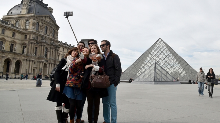 Des touristes devant le Louvre le 7 mars 2015 à Paris