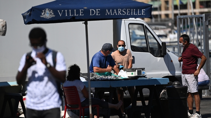 Des vendeurs de rue avec des masques de protection, le 26 août 2020 sur le vieux port à Marseille