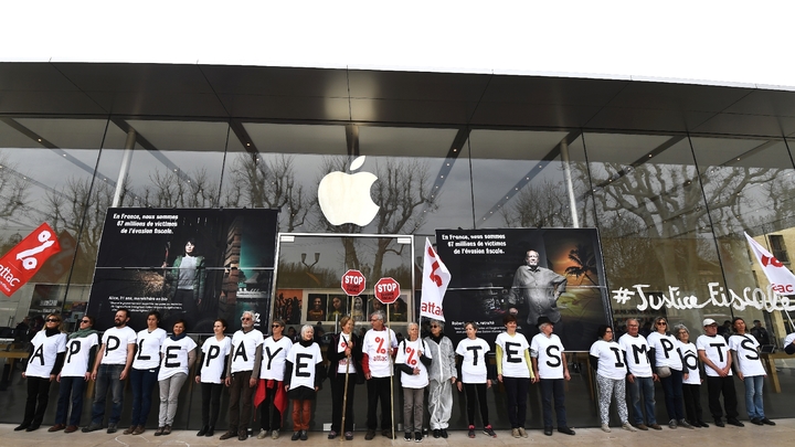 Des militants de l'association Attac mobilisés devant un magasin Apple à Aix-en-Provence pour protester contre la politique d'optimisation fiscale du géant américain, le 7 avril 2018
 