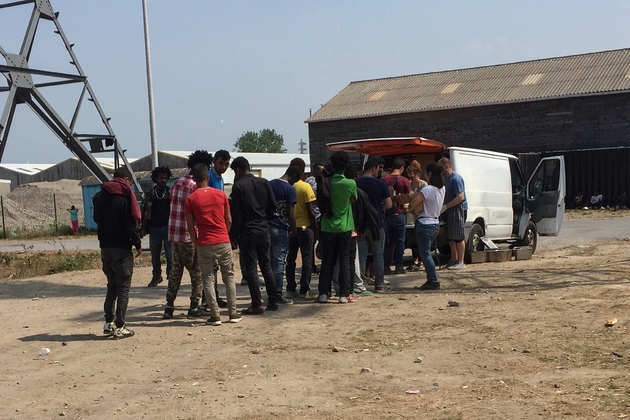 Des migrants font la queue pour recevoir de l'aide alimentaire à Calais (nord), le 21 juin 2017