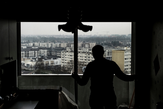 Un homme à la fenêtre de son appartement le 7 février 2017 à Vaulx-en-Velin