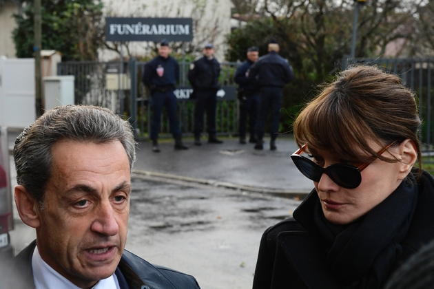 L'ancien président Nicolas Sarkozy (G) et Carla Bruni-Sarkozy parlent aux journalistes devant le funérarium du Mont-Valérien, où repose la dépouille de Johnny Hallyday, le 8 décembre 2017 à Nanterre, près de Paris