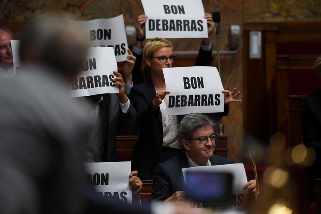 Des membres de La France insoumise (LFI) brandissent des pancartes disant 