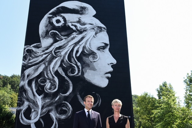 Emmanuel Macron et l'artsite de steet art Yseult Digan, qui signe YZ, posent devant une fresque de Marianne sur la façade d'un HLM à Périgueux, le 19 juillet 2018
