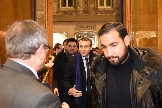 Photo en date du 13 décembre 2016 montrant Emmanuel Macron (C), à l'époque candidat à la présidentielle, précédé par son garde du corps Alexandre Benalla (D), dans une librairie de Bordeaux