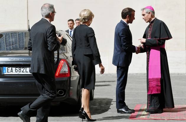 Le président français Emmanuel Macron (C) arrive au Vatican avec son épouse Brigitte (3eD), accueilli par l'archevêque Georg Gaenswein, préfet de la maison pontificale (D), le 26 juin 2018