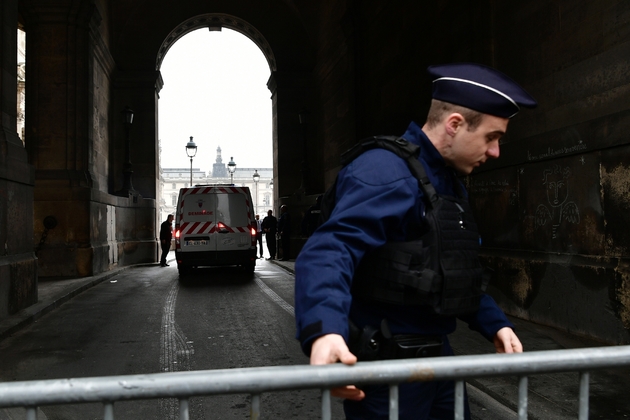 Un policier dresse une barrière pour interdire l'accès à l'esplanade du Louvre, le 7 mai 2017 à Paris, après l'évacuation