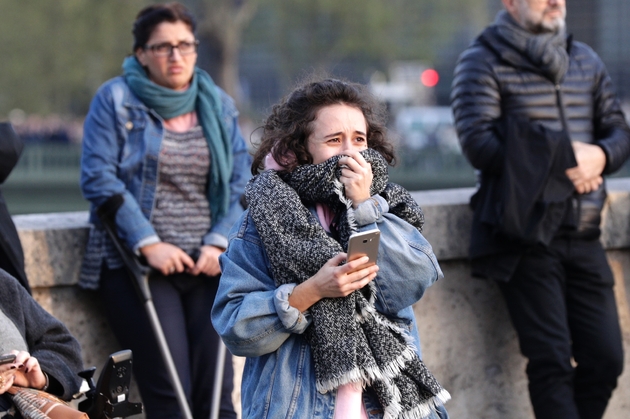 Une jeune femme en larmes devant Notre Dame en flammes, à Paris le 15 avril 2019