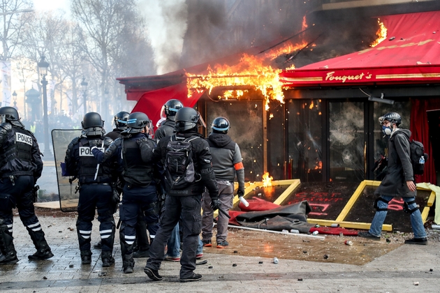 Les forces de police devant Le Fouquet's en feu, sur les Champs Elysées, à Paris, le 16 mars 2019