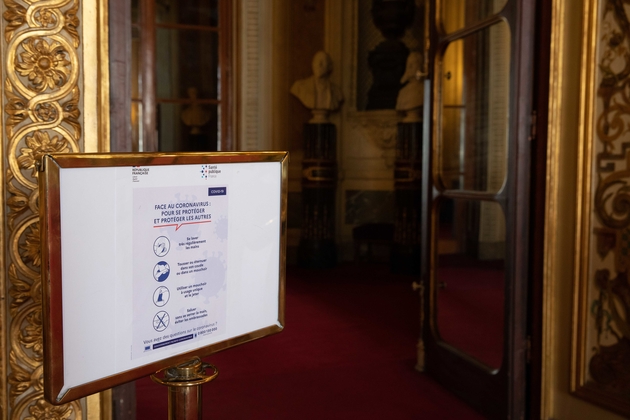 Une pancarte rappelle les gestes 'barrière' en salle des conférence du Sénat