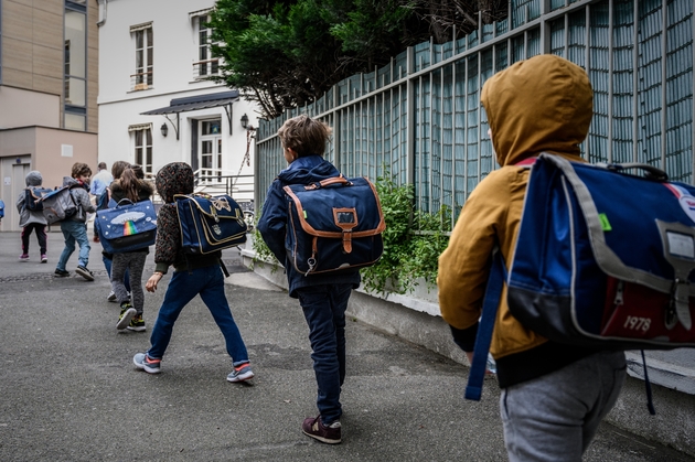 Des élèves se dirigent vers leur école en respectant une distance de sécurité, le 12 mai 2020 à Paris
