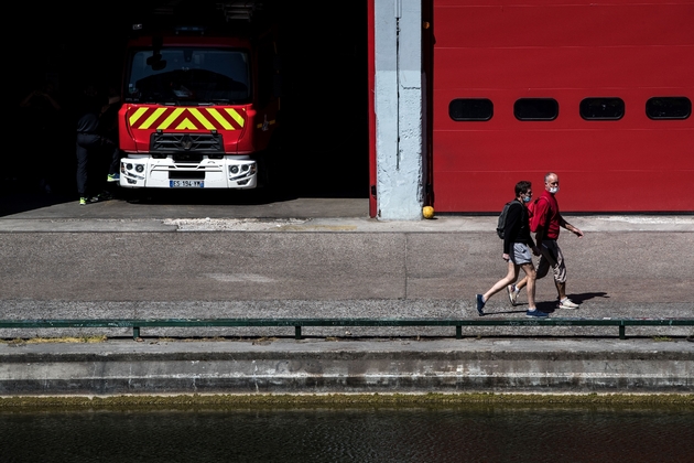 Des promeneurs devant une caserne de pompiers le 26 avril 2020 à Paris