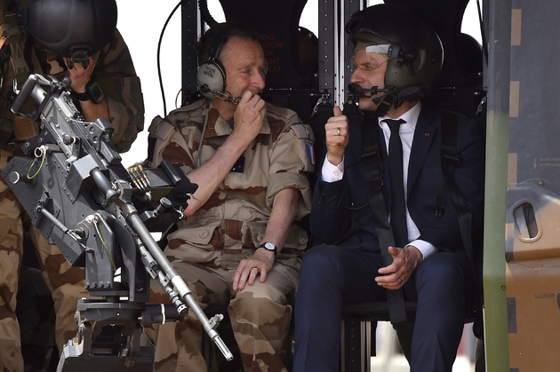 Le chef d'état-major des armées le général Pierre de Villiers (g) parle avec le président Emmanuel Macron en hélicoptère, après une visite aux troupes françaises de l'opération Barkhane, le 19 mai 2017 à Gao, dans le nord du Mali