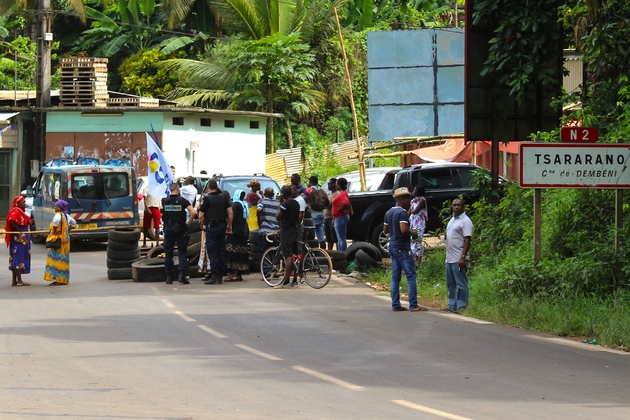 Des gendarmes parlent avec des habitants qui ont bloqué une route pour protester contre l'immigration clandestine et l'insécurité, le 5 avril 2018 à Tsararano, à Mayotte