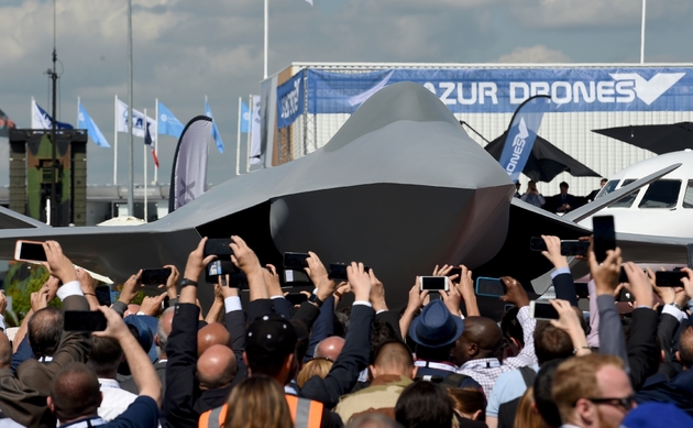 Des visiteurs assistent à la présentation d'une maquette grandeur nature du futur avion de combat  européen du programme SCAF (système de combat aérien du futur), à l'aéoport du Bourget, près de Paris, le 17 juin 2019 