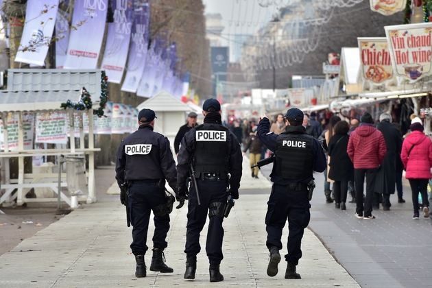 Des policiers  patrouillent le long des échoppes du marché de Noël aux Champs-Élysées à Paris, le 20 décembre 2016