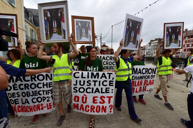 Des manifestants brandissent des portraits du président français Emmanuel Macron, décrochés dans les mairies, à Bayonne le 25 août 2019 