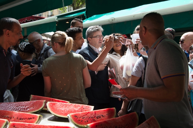 Jean-Luc Melenchon (C) se prête volontiers aux selfies avec les commerçants et les passants, qui s'avancent pour voir le candidat, sur un marché à Marseille, le 18 mai 2017