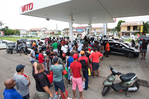Des automobilistes attendent dans une station-service fraîchement réapprovisionnée à Cayenne le 26 mars 2017