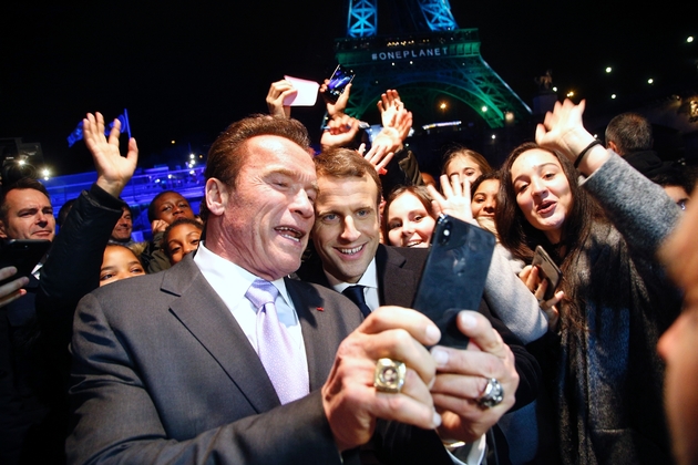 Le président Emmanuel Macron pose pour un selfie avec l'acteur américain Arnold Schwarzenegger, devant la Tour Eiffeil, le 12 décembre 2017 à Paris
