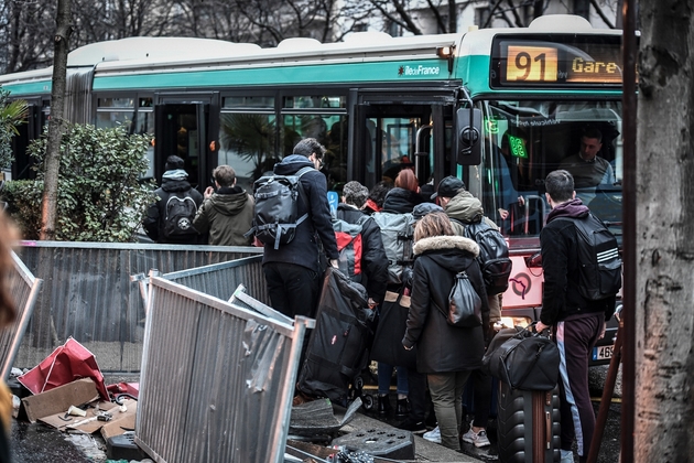 Des usagers tentent de monter dans un bus près de la Gare Montparnasse à Paris, le 2 janvier 2020, au 29e jour de grève dans les transports