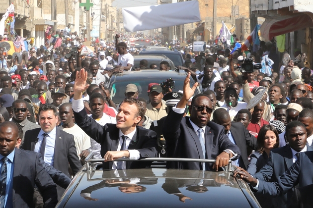 Les présidents français et sénégalais, Emmanuel Macron et Macky Sall, saluent la foule lors d'une visite à Saint-Louis, dans le nord du Sénégal, le 3 février 2018.