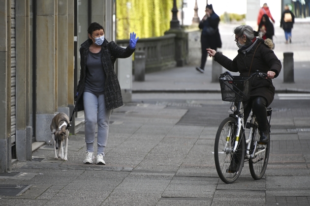 Des passants se saluent, à distance, dans les rues de Strasbourg, le 17 mars 2020 