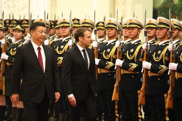 Le président Emmanuel Macron et son homologue chinois Xi Jinping (g) passent en revue la garde d'honneur, au Palais du Peuple, le 9 janvier 2018 à Pékin