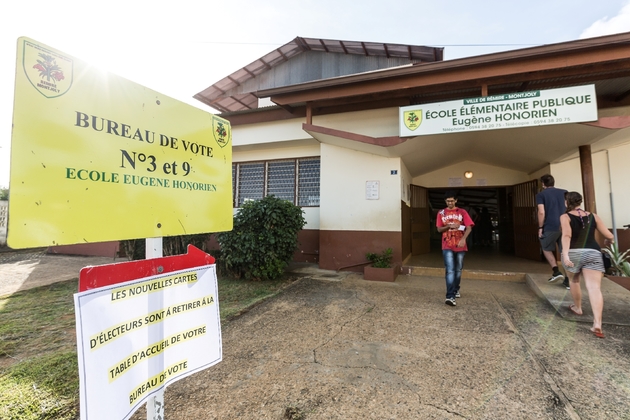 Des électeurs entrent et sortent d'un bureau de vote de Remire-Montjoly en Guyane, le 22 avril 2017