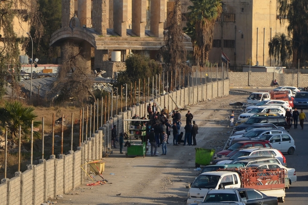 Des irakiens vendent des livres dans une rue à l'extérieur de l'université endommagée par des raids, le 12 janvier 2018 à Mossoul, six mois après la reprise de la ville aux djihadistes de l'EI