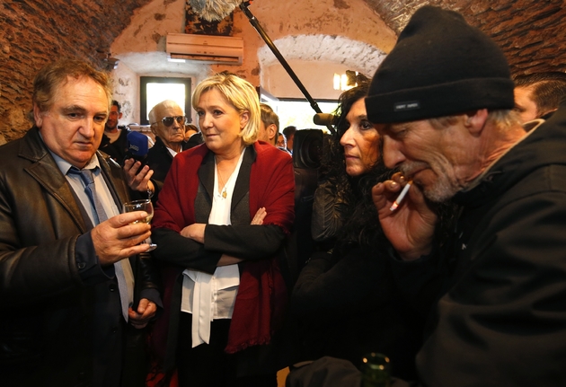Marine Le Pen parle aux clients d'un bar à Pruno en Corse le 26 novembre 2017, lors d'une visite pour soutenir Charles Giocomi