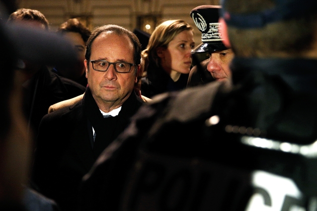 Le président français François Hollande (G) regarde un officier de police lors d'une visite du dispositif de sécurité mis en place pour le nouvel an à Paris le 1er janvier 2016 