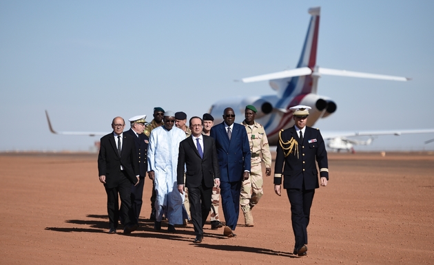 François Hollande (C), le Premier ministre malien Modibo Keita (3e D), le ministre français de la Défense Jean-Yves Le Drian (G), le 13 janvier 2017 lors de la visite aux troupes de l'opération antiterroriste Barkhane à Gao, dans le nord du Mali