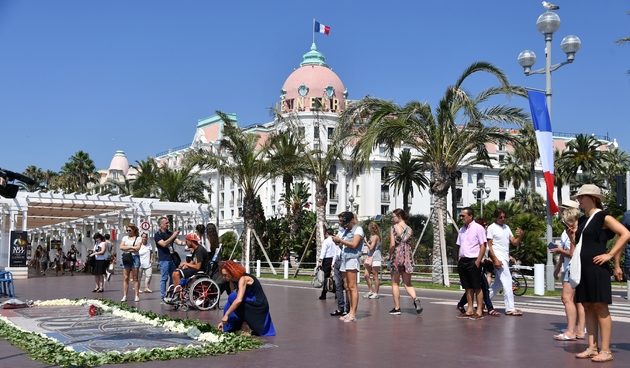 Des personnes se recueillent sur la Promenade des Anglais à Nice en hommage aux victimes de l'attentat d'il y a un, le 14 juillet 2017
