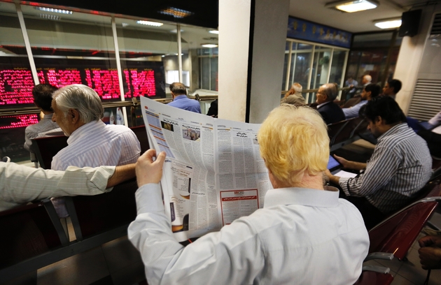 Des personnes surveillent les indices boursiers à la Bourse de Téhéran, le 8 mai 2018