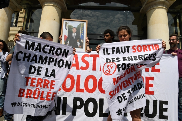 Des manifestants décrochent un portrait du président Macron à la mairie du XIXe arrondissement de Paris le 24 mai 2019