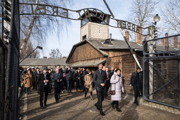 Le Premier ministre français Edouard Philippe entre par le portail d'accès à l'ancien camp de concentration nazi d'Auschwitz (Pologne), le 27 janvier 2020, pour le 75e anniversaire de sa libération