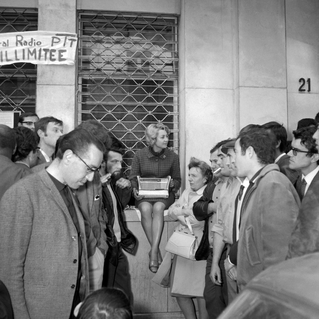 Des grévistes des PTT sont regroupés autour d'un transistor à Paris, le 30 mai 1968, pour écouter l'allocution de Charles de Gaulle