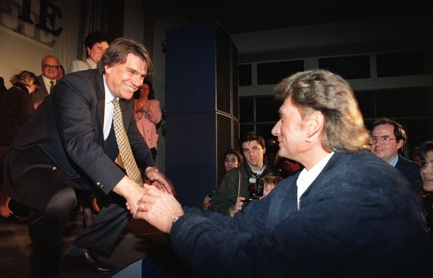 Bernard Tapie, tête de liste Energie Sud aux élections régionales, serre la main du chanteur Johnny Hallyday, venu lui apporter son soutien lors d'un meeting le 19 mars 1992 à Toulon