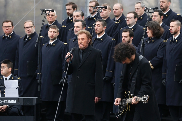 Johnny Hallyday chante avec le choeur de l'armée française pendant une cérémonie place de la République à la mémoire des attentats de Paris le 10 janvier 2016