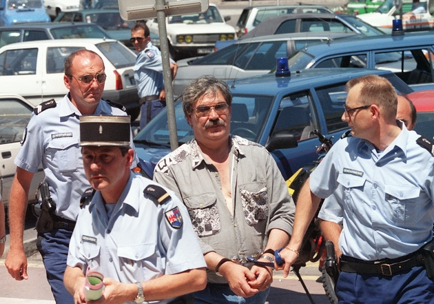 Gérard Finale (C) arrive au Palais de Justice de Toulon, encadré par des gendarmes, le 22 juin 1994