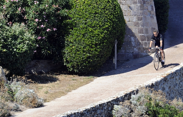 L'ancien président français Nicolas Sarkozy sort à vélo du fort de Brégançon où il passe ses vacances le 23 juillet 2011