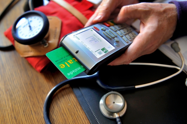Un médecin utilise la carte vitale d'un patient lors d'une consultation le 23 septembre 2013 à Godewaersvelde