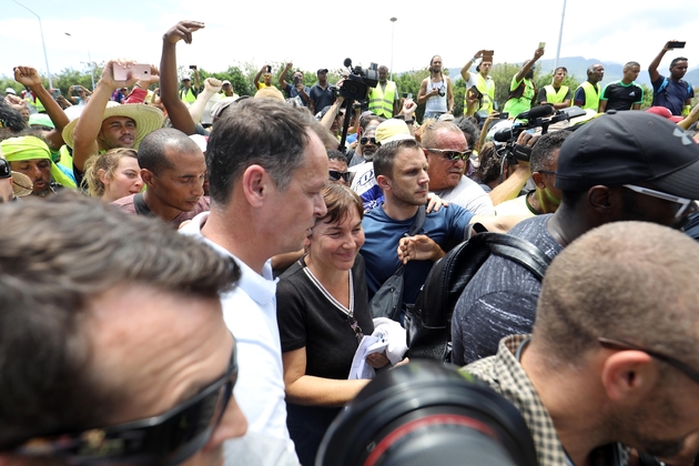 La ministre des Outre-mer Annick Girardin (C) et le préfet de La Réunion Amaury de Saint-Quentin (C, gauche) arrivent à Sainte-Marie, le 28 novembre 2018, alors que des 